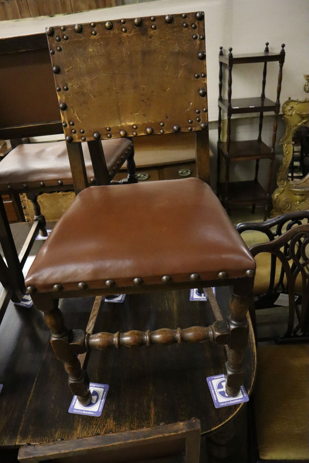 A 1930s oak extending dining table 234cm extended (two spare leaves) and seven dining chairs (one with arms)